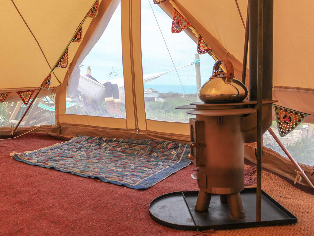 View of a person lying in a hammock from inside a 4m ultimate pro mesh bell tent with traveller stove
