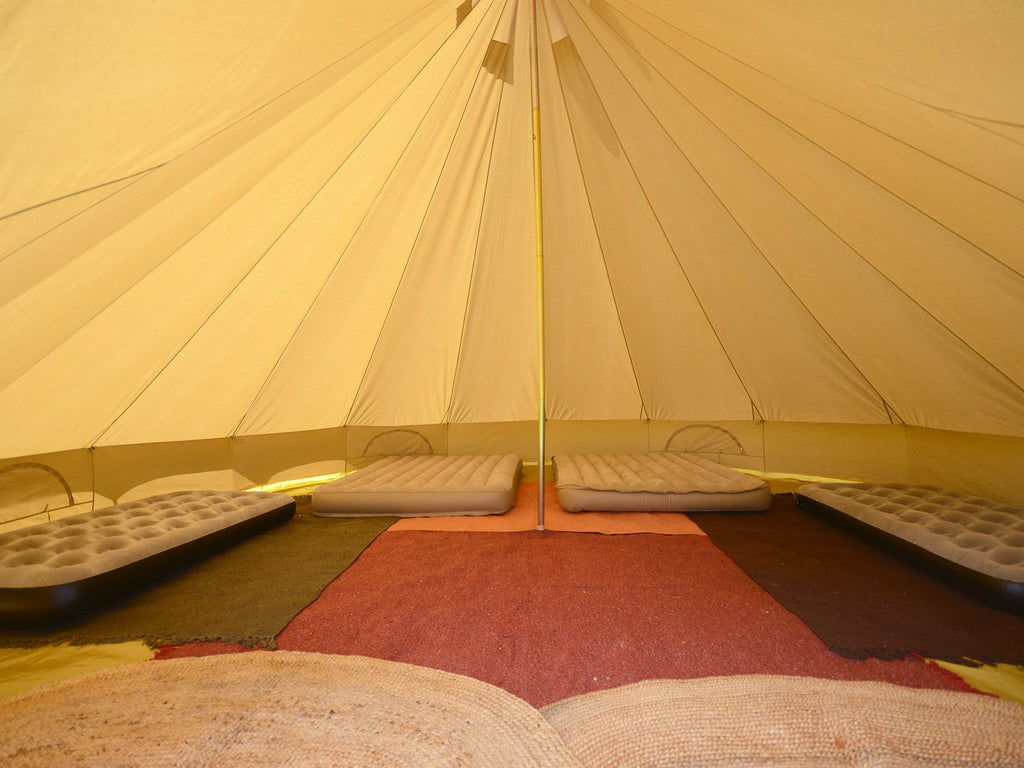 Interior of a 6m standard bell tent with rugs and mattresses