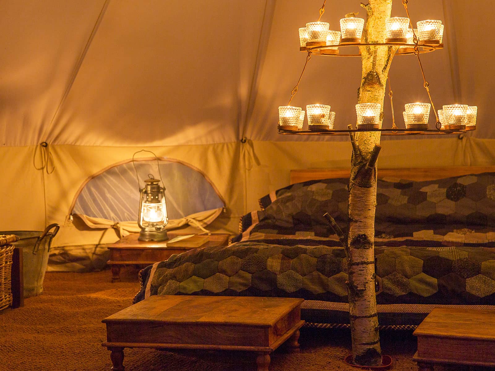Bell tent with tree branch centre pole and double tier clear tea light chandelier