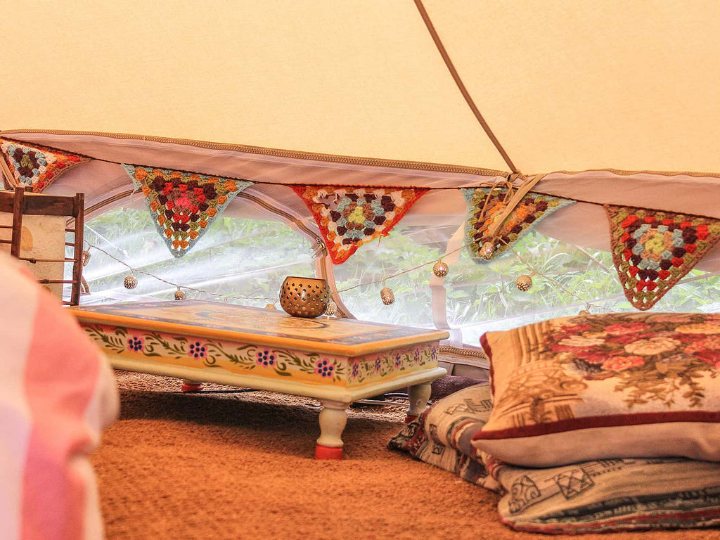 Hand painted low level table inside a bell tent