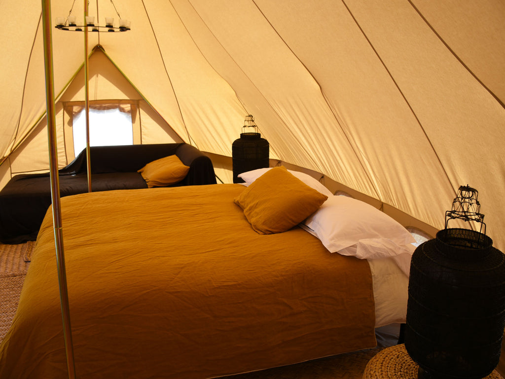 Full sized double bed and sofa inside an emperor ultimate bell tent