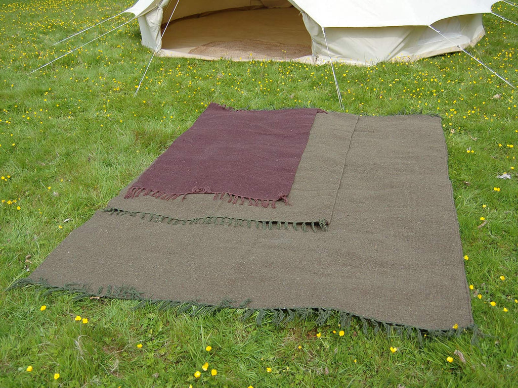 Green eco natural hand loomed rugs on grass infront of a bell tent