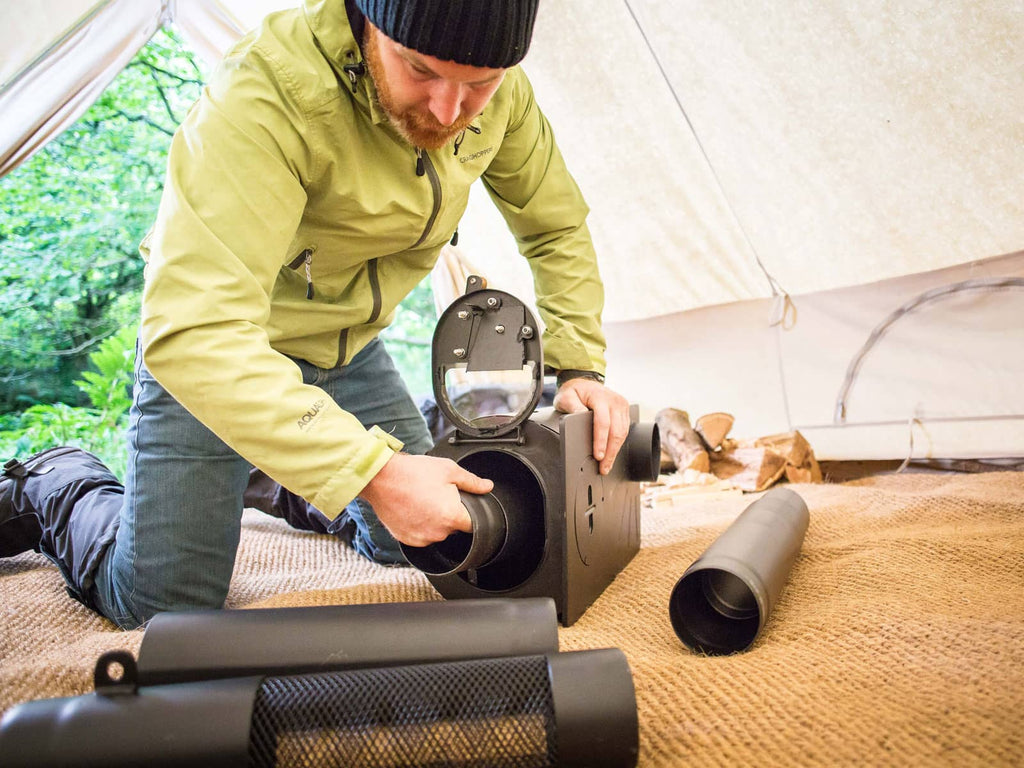 Person unpacking the flue pipe from inside a frontier plus stove