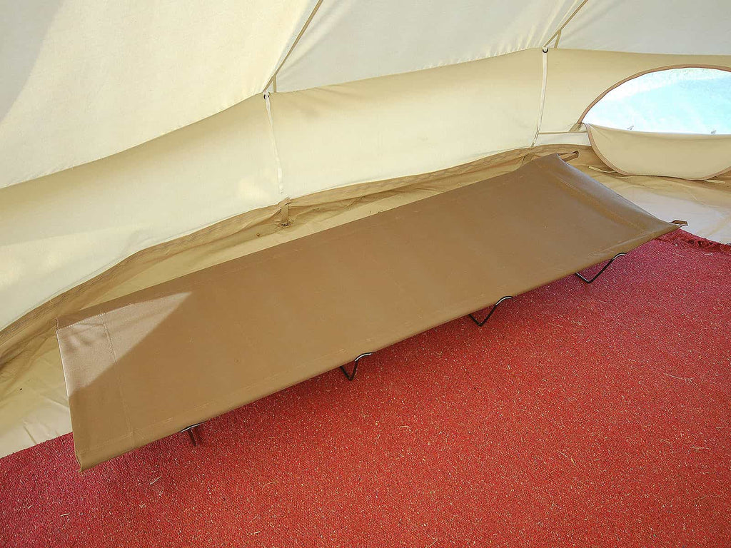 Collapsible camp bed inside a bell tent