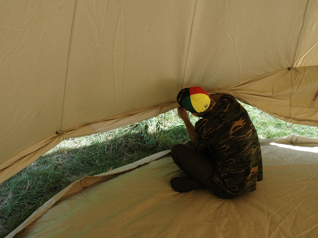Person inside a 4m ultimate bell tent rolling the walls up