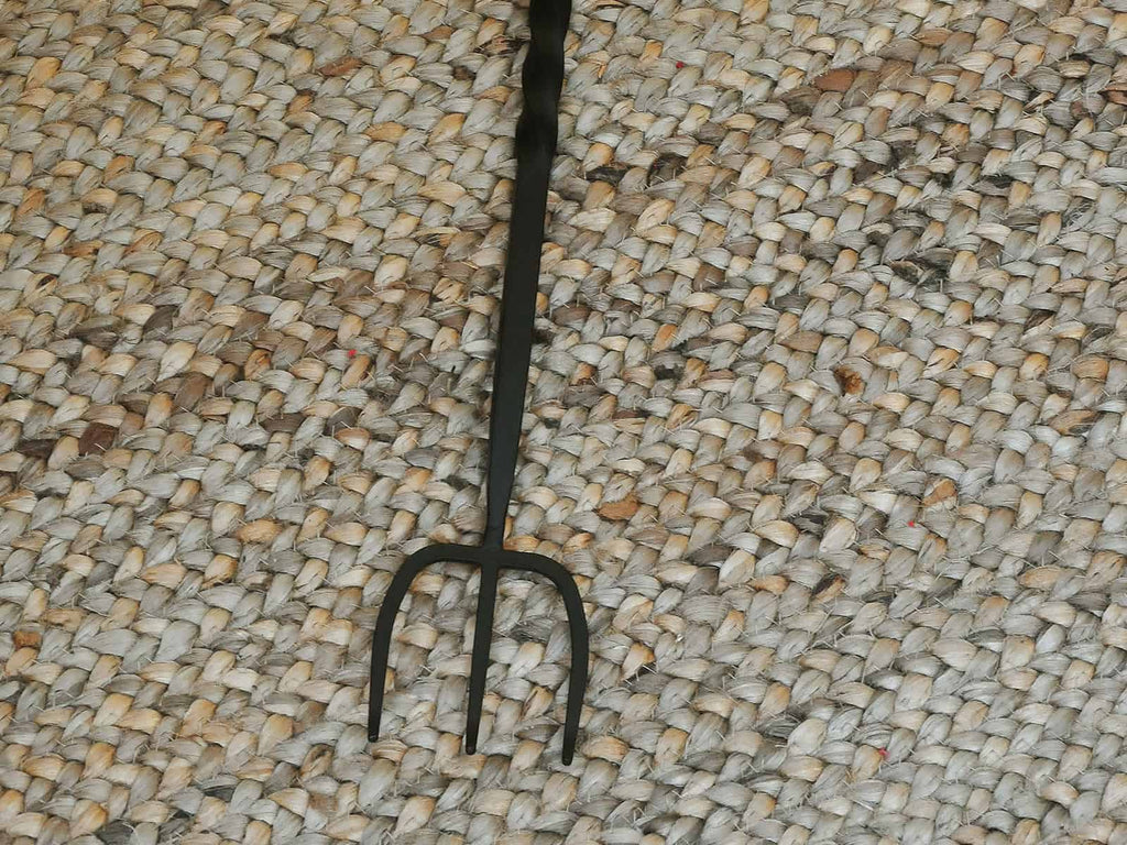 3 pronged cast iron toasting fork on jute door mat