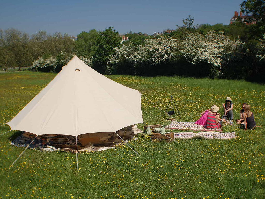 4m standard bell tent and people in a field of buttercups