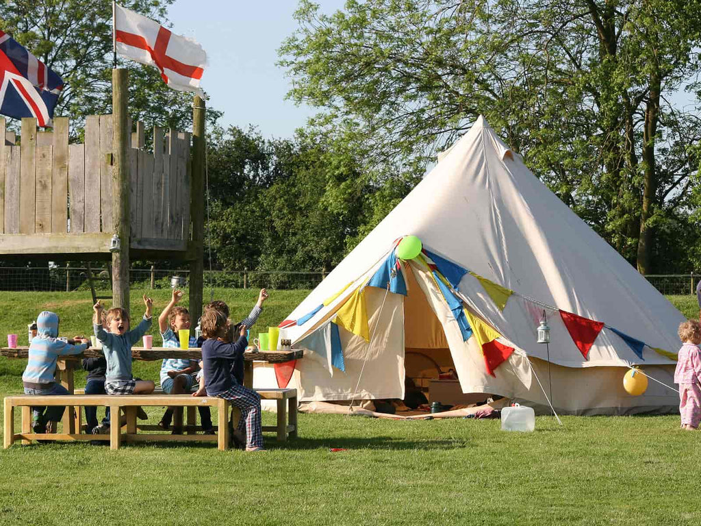 5m deluxe bell tent with bunting and children having a picnic