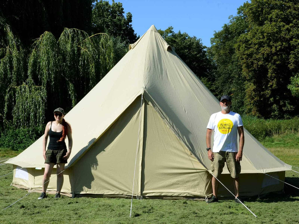 Two people stood in front of a 6m ultimate twin door pro mesh bell tent 
