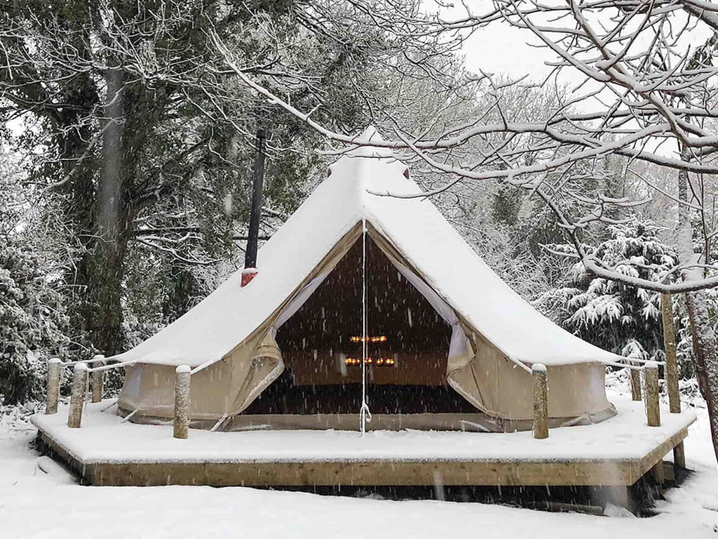 Bell tent with stove and double tea light chandelier in the snow