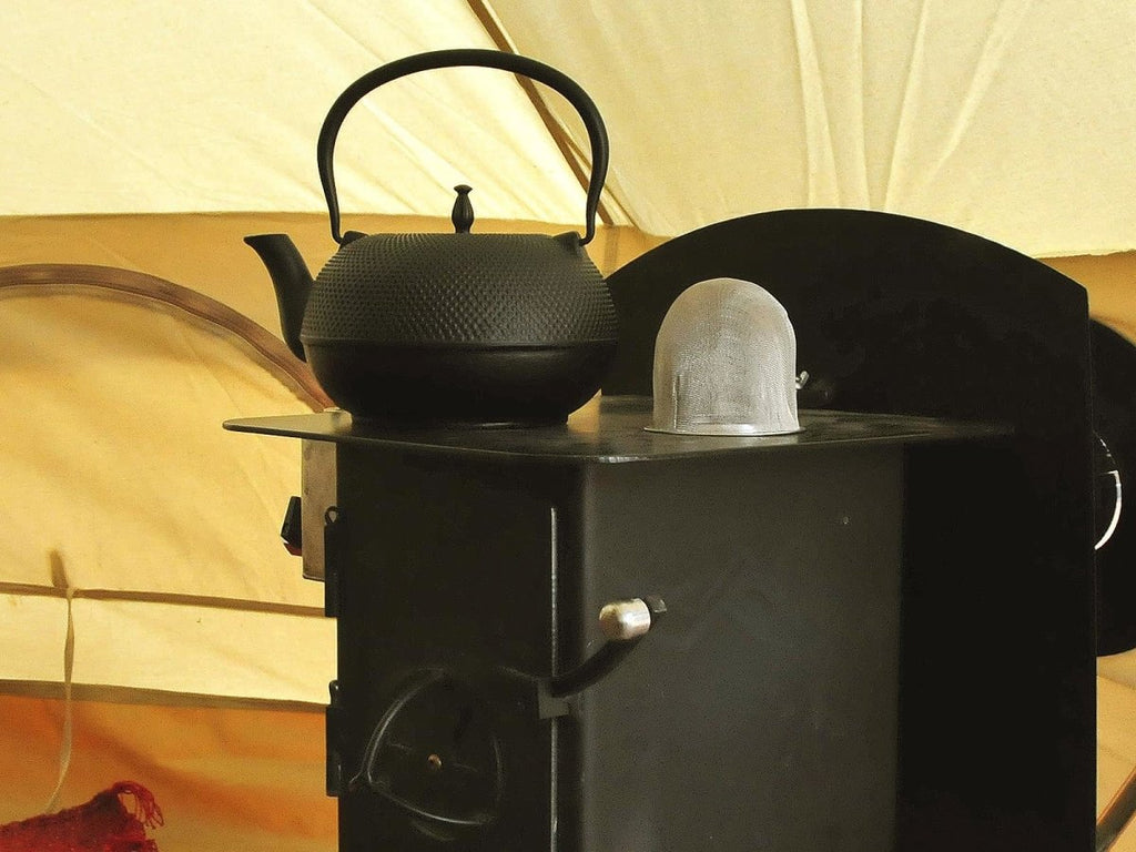 Cast iron tea kettle on a tent stove
