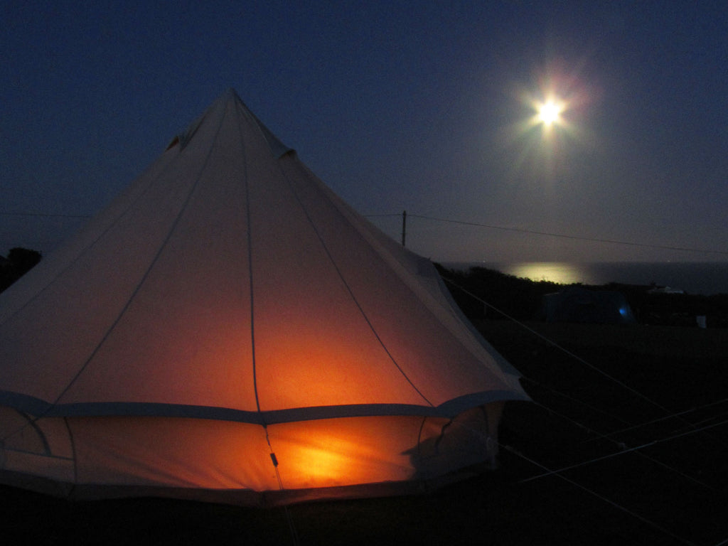 4m deluxe bell tent at night camping beside the sea