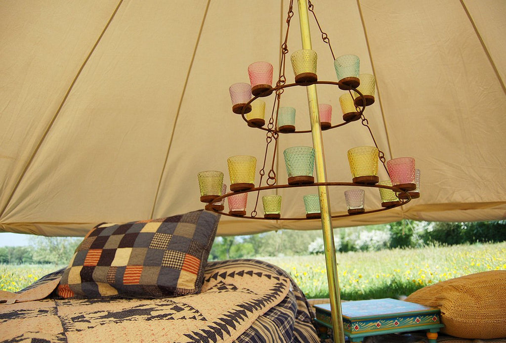 Double tier multi coloured glass tea light chandelier in a bell tent with the wall rolled up