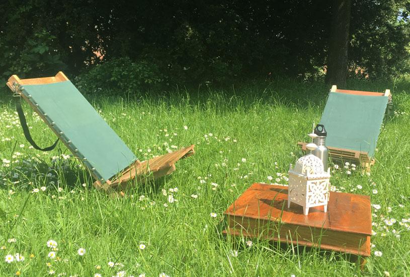 Two portable hand-made deckchairs indian table and lantern