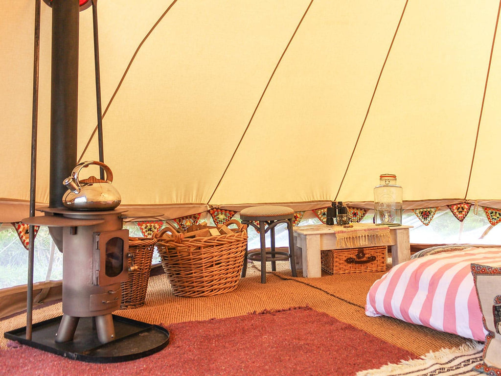 Coir matting, rugs and wood burning stove inside a 5m ultimate pro mesh bell tent