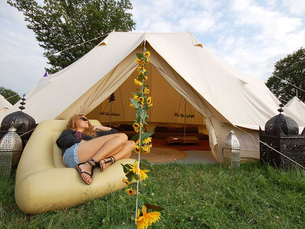 Lady relaxing in front of a fully furnished emperor standard bell tent