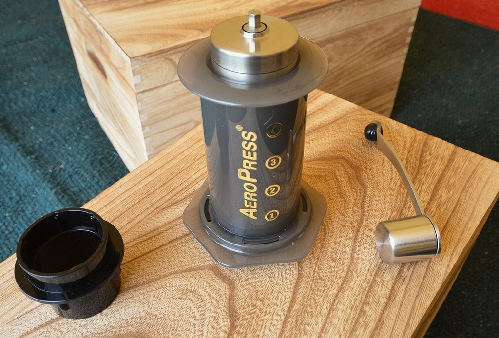 Portable coffee grinder nesting inside an aeropress